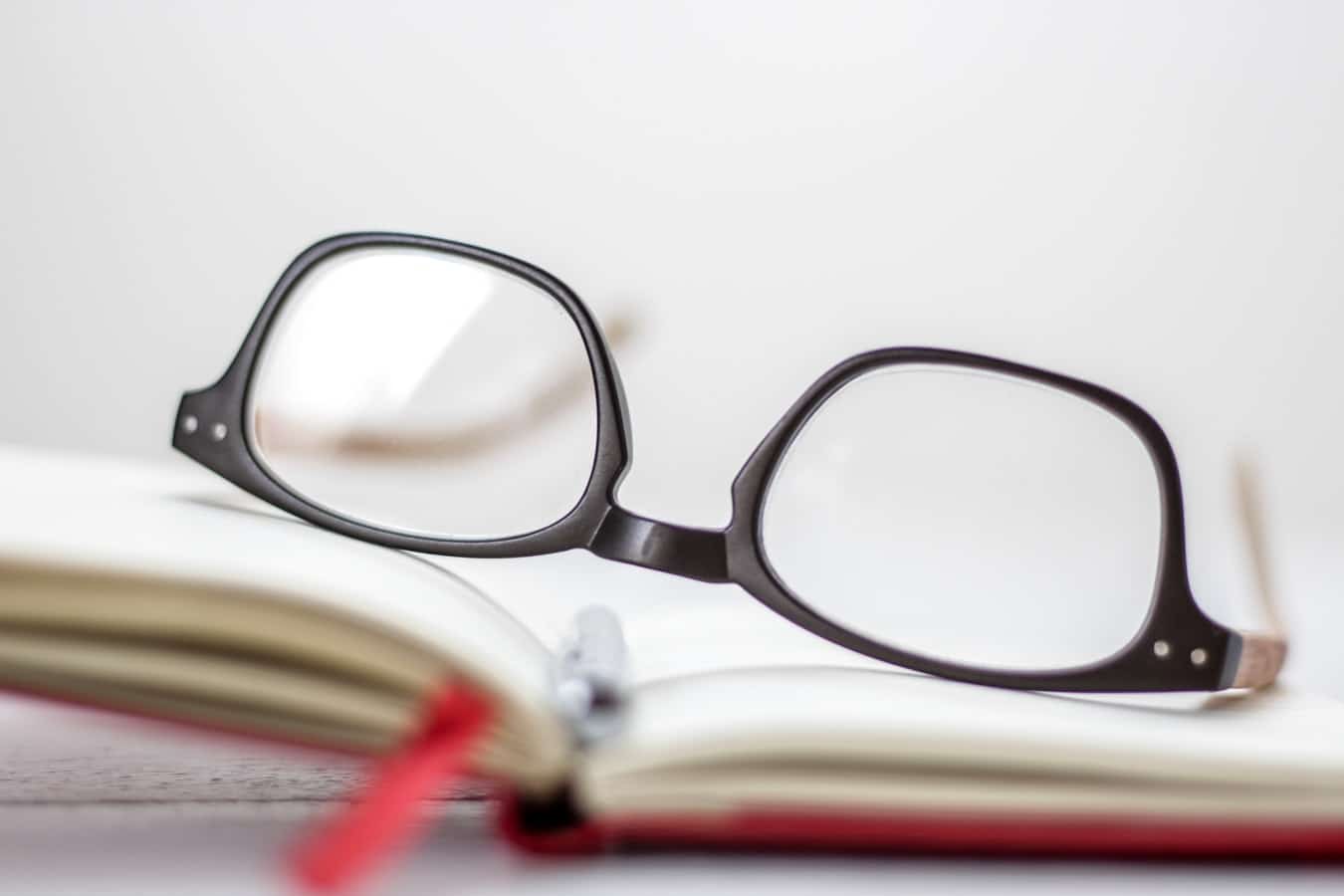 Paire de lunettes presbyte posée sur un livre pour la lecture