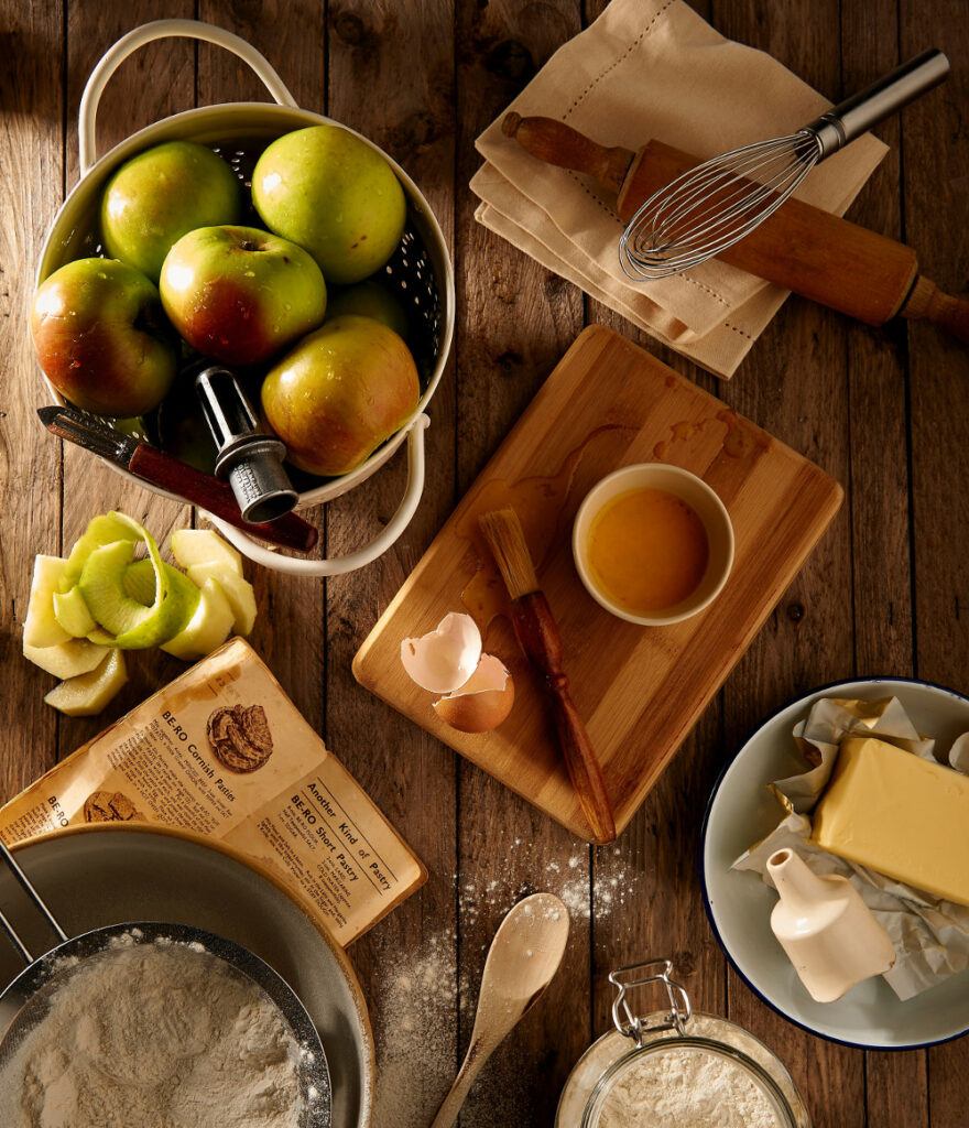 vue de haut sur une table avec ingrédients pour faire un gateau beurre pommes farine oeufs